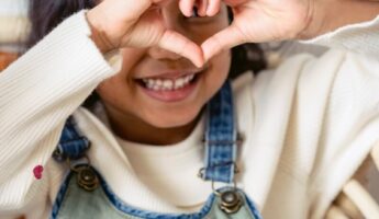 Young girl making a heart with her hands
