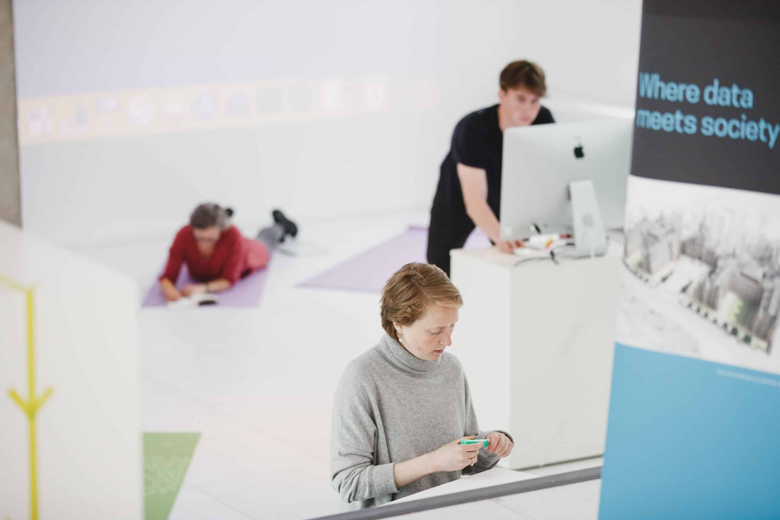 Three people writing in a workshop