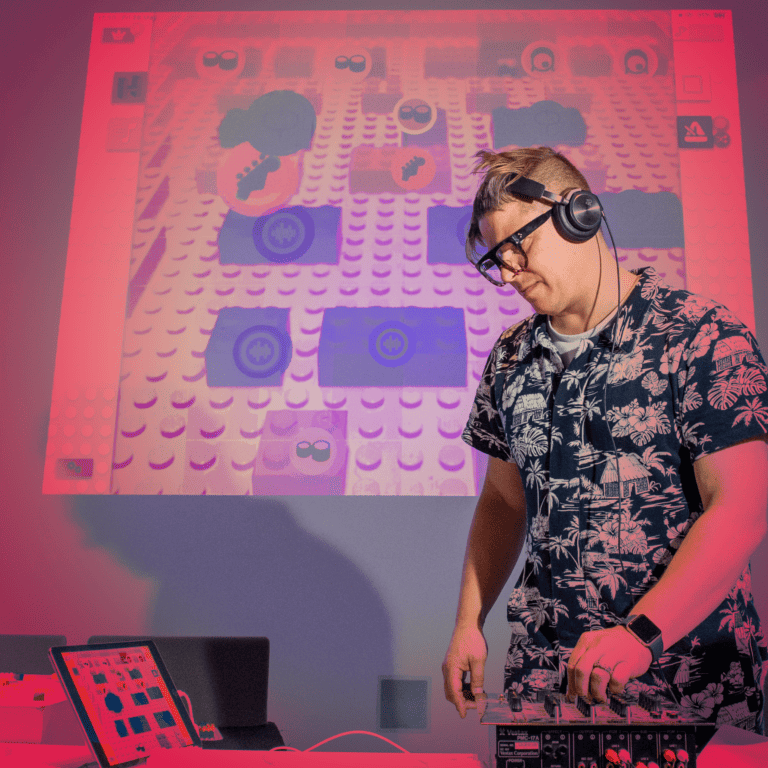 A DJ standing over his decks, red tint over image.
