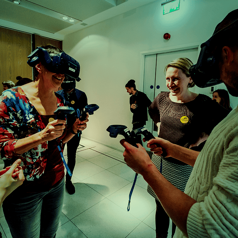 Group of people using VR headsets, green tint over image.