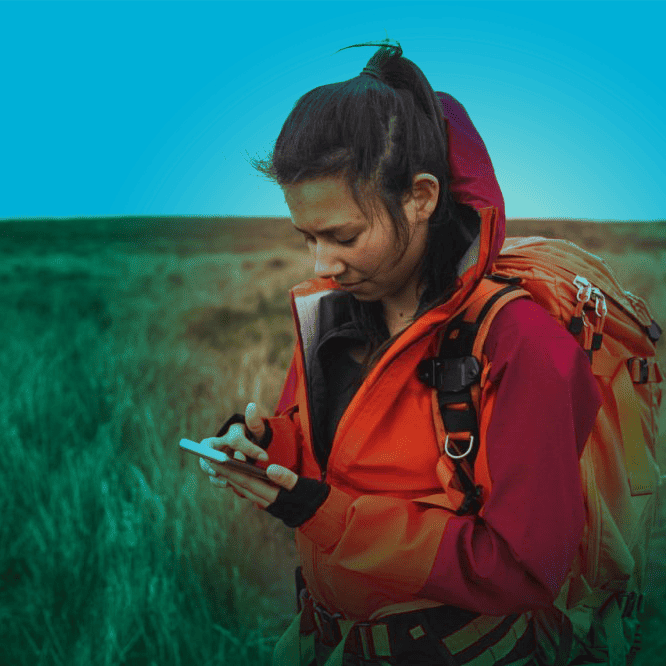 person in nature looking at smartphone