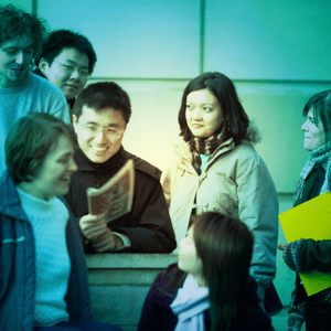 A group of undergraduate students outside a building, green tint over image.