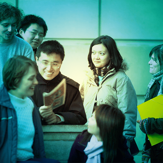 A group of undergraduate students outside a building, green tint over image.