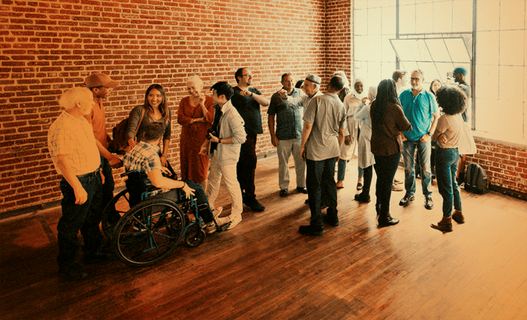 Large Group in Room: Orange Tint A large group of people meeting in an empty room with bricked walls, orange tint on image.