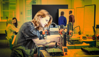 Student focused operating a 3-d printer machine