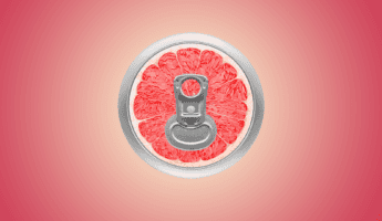 Fizzy Drinks A close-up of a beverage can's pull tab, with the top resembling a sliced red grapefruit. The grapefruit appears juicy and vibrant. The background is a gradient of pink and red, enhancing the fruit's color.
