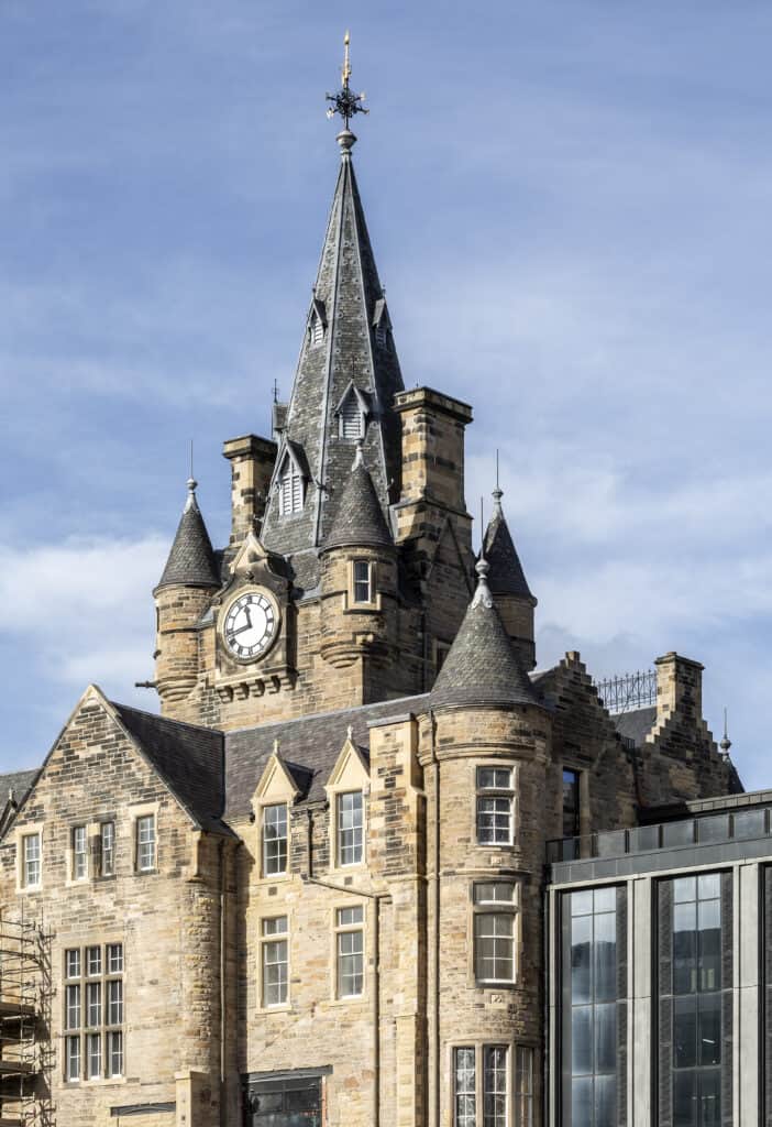 Close up of brick clocktower and tiled roof.