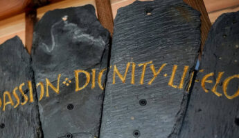 Slate from the Spirit Case sculpture displaying the words 'dignity'