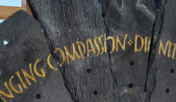 Slate from the Spirit Case sculpture displaying the words 'compassion'